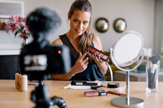 Young female vlogger recording a make-up broadcast for her vlog.
