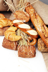 Different kinds of bread rolls on white board from above. Kitchen or bakery poster design.