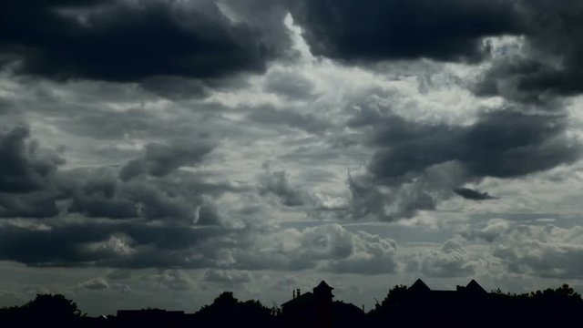 Cloudy sky and silhouettes of houses