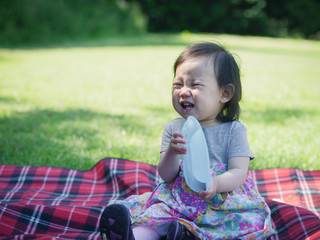 baby girl has a picnic in summer garden