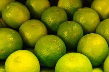 Fresh apetitic limes, laid out in a box.