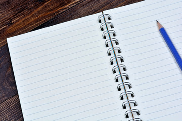 Empty notebook with pencil on table