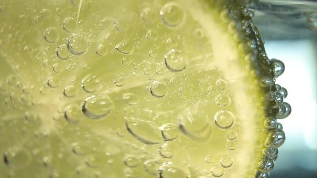 Lemon slice in fresh water bubbles. Macro shot