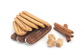 Biscuits, cane sugar, cinnamon sticks on white background