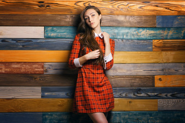 Woman student in red dress on colorful Wooden Wall Background