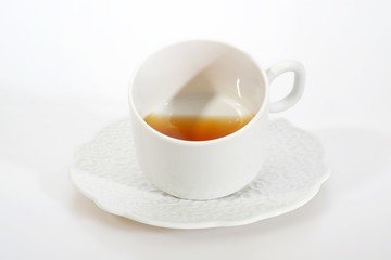 Porcelain cup with tea on white background