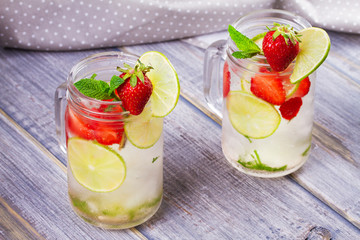 Strawberry mojito. Detox fruit and berry infused flavored water in jars. Refreshing summer homemade cocktail
