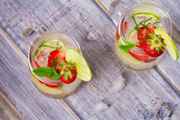 Strawberry mojito. Detox fruit and berry infused flavored water in jars. Refreshing summer homemade cocktail. View from above, top studio shot