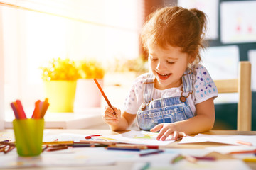 Fototapeta premium child girl draws with colored pencils