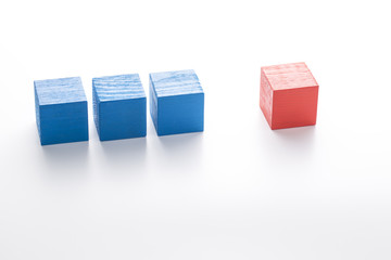 Three blue wooden cubes and red one. Individuality concept.