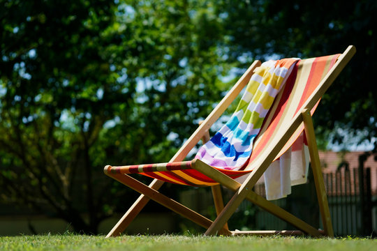 Chaise longue et serviette de plage dans le jardin