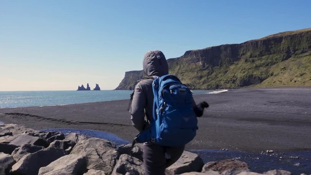 Woman exploring beautiful Reynisfjara beach near Vik, Icealnd