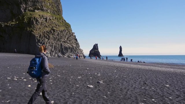 Woman exploring beautiful Reynisfjara beach near Vik, Icealnd