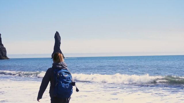 Woman exploring beautiful Reynisfjara beach near Vik, Icealnd