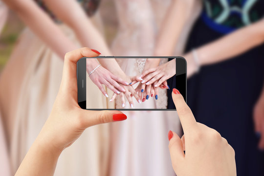 Group of girls showing their nails while another girl taking picture of them with phone