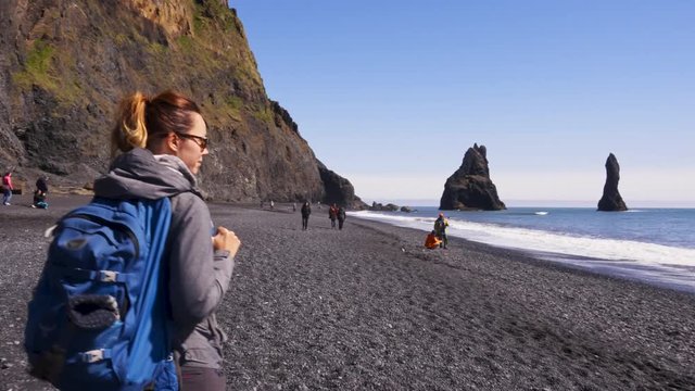 Woman exploring beautiful Reynisfjara beach near Vik, Icealnd