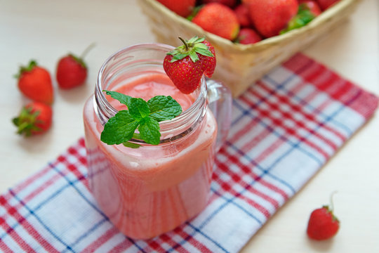 Strawberry smoothies in a glass jar, berries, and mint  Healthy food concept