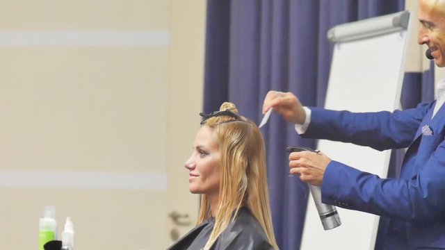 Hairdresser In Action. Barber and customers. hairstyle models for white hair. Blonde in the cabin. Work in the cabin. Barber shears white hair model client. close-up.