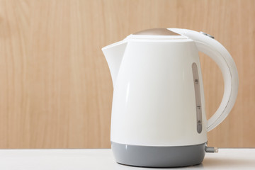 White Electric kettle quick boil on table and wooden background.