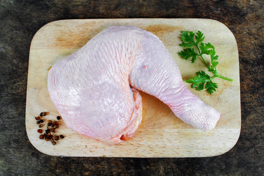 Fresh raw chicken legs arrangement on kitchen cutting board