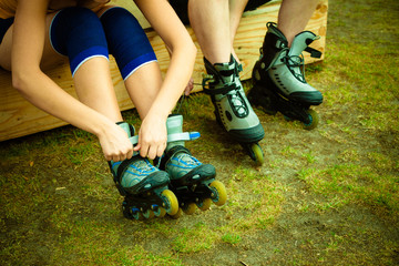 Woman and man putting on roller skates