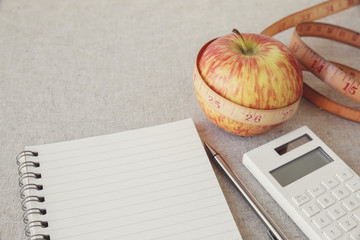 Apple, tape measure, notebook and calculator background for diet plan, weight loss plan