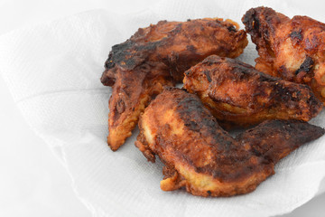 burnt fried chicken wings on white tissue background  for reduced the cooking oil, copy space