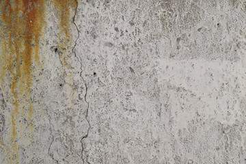 Background of gray cement wall with ginger rust, small holes and crack texture.