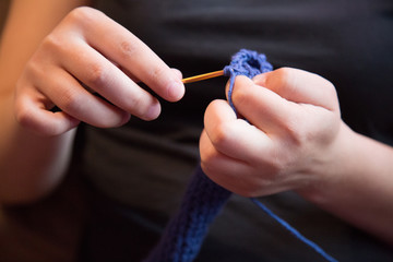 Closeup blue woolen yarn female fingers