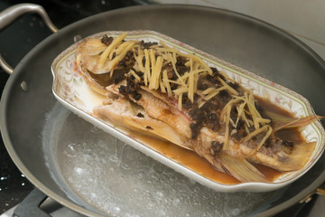 steaming a fresh fish on a pot at home