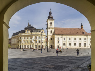 Fototapeta na wymiar The famous Piata Mare, Large Square, Sibiu, Romania, framed by an arch, with the Holy Trinity church in the background