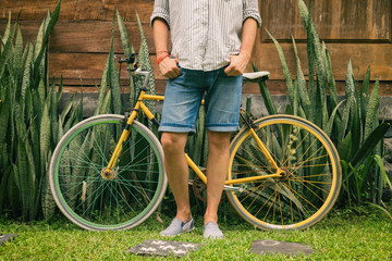 Naklejka premium Young attractive man enjoying outdoors with old bicycle.
