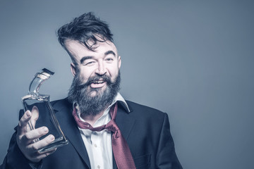 Distorted image of a bearded man in suit with a bottle of alcohol in his hand on a gray background