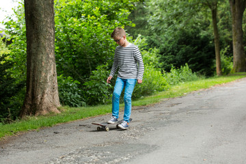 Fototapeta na wymiar Jugendlicher / Kind / Heranwachsender spielt mit Skateboard / Fährt Skateboard