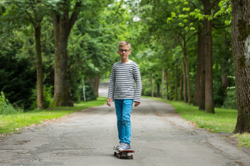 Fototapeta premium Jugendlicher / Kind / Heranwachsender spielt mit Skateboard / Fährt Skateboard