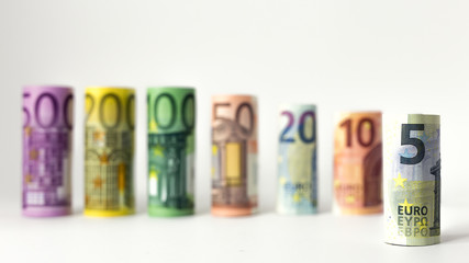 Obraz na płótnie Canvas Gerollter 5 Euro Schein mit anderen Geldscheinen im Hintergrund