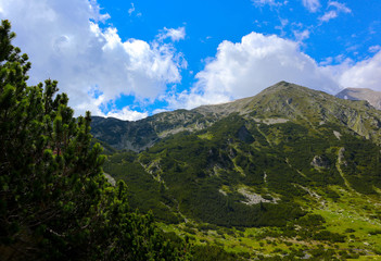 Beautiful view on the high green mountains peaks, on the blue sky background. Mountain hiking paradise landscape, no people.