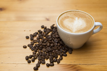 Latte art with coffee beans on wood table