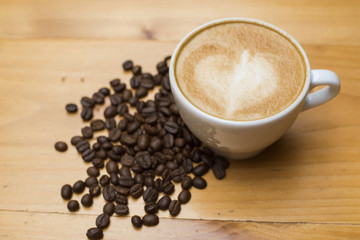 Latte art with coffee beans on wood table