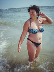 Obraz premium Usual simple American women plus size rests near water under the sun