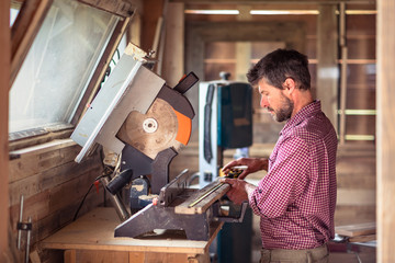 Carpenter measuring plank with ruler