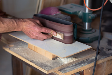 Carpenter's Hand using electric sander tool