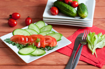 sliced tomatoes and cucumbers lie on a plate
