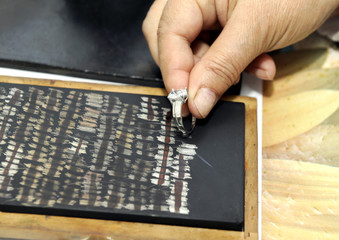 Jeweler inspects silver ring with acid to verify its authenticity