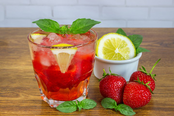 Glass of cold tea with mint,strawberry,lemon, on table