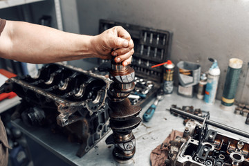 mechanic repairman at automobile car engine maintenance repair work. the crankshaft of the engine