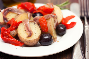 salad with anchovies on white plate