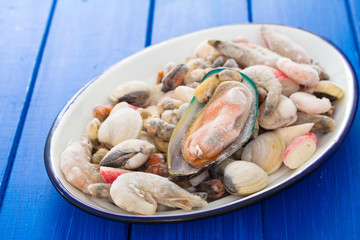 seafood in ice on dish on wooden background