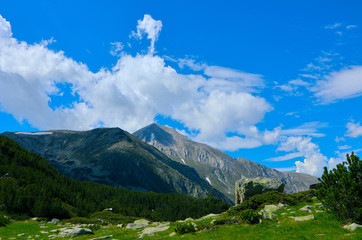 Beautiful view on the high green mountains peaks, on the blue sky background. Mountain hiking paradise landscape, no people.