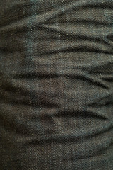 Wrinkled of dark indigo denim jeans texture background. close up dark denim pants texture fashion style.